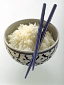 Reis in asiatischem Schälchen mit Stäbchen