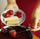 Dipping A Strawberry into Chocolate Fondue
