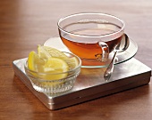 Tee in Glastasse; Zitronenschnitze