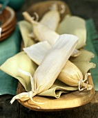 Four Tamales on Wooden Tray