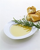 Olivenöl auf Teller mit Rosmarin und Baguette