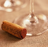 A wine cork beside the stem of a wine glass