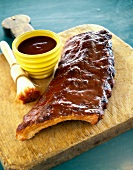 Spare-ribs brushed with barbecue sauce on a wooden board