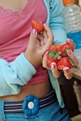 Junges Mädchen hält frische Erdbeeren
