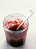 Raspberry Jam in a Glass Jar with a Spoon