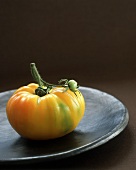 A Yellow Tomato on a Black Plate