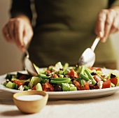 A Greek Salad Being Tossed