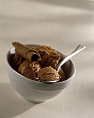 Chocolate ice cream with chocolate rolls in bowl with spoon