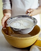 Sieving flour into bowl