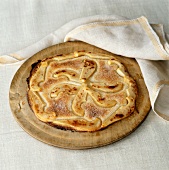 An apple and cinnamon pancake on a wooden board