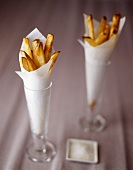 Pommes frites in Papiertüten in zwei Gläsern; Salz