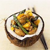 Sweet and sour chicken ragout in hollowed-out coconut