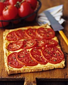 Tomaten-Käse-Tarte auf Holzschneidebrett