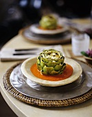 A Table Setting with Cheese Sprinkled Artichokes in Tomato Sauce