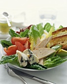 A Romaine Salad with Chicken, Blue Cheese, Avocado, Tomato and Toasted Bread