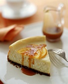 Piece of cheesecake with candied oranges & caramel sauce