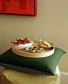 A Round Tray with Crayfish, Stuffed Pattypan Squash and Empanadas on a Pillow