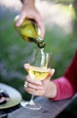 Weißwein aus Flasche in Glas einschenken (aussen)