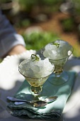 Person serving two glasses of lime granita on tray