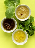 Three different salad dressings in small bowls