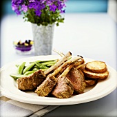 Lamb cutlets with pea pods and fried potato slices