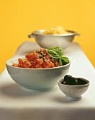 Zutaten für Nudelsauce: Tomaten, Basilikum und Oliven