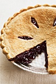 A Blueberry Pie with Slice Removed in a Foil Pan
