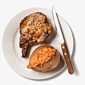 A Pan Fried Pork Chop with Sweet Potato and a Steak Knife