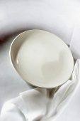 Empty white plate and white tablecloth