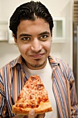 A Man Holding a Slice of Cheese Pizza and Looking Directly at the Camera