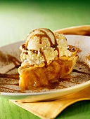 A Slice of apple pie with vanilla ice cream and drizzled caramel