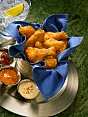 Spicy Chicken Wings in a Silver Bucket on a Tray with Various Dips