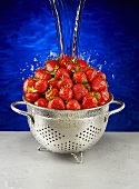 Water Pouring Over Strawberries in a Metal Colander