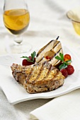 A Grilled Pork Chop with a Grilled Pear Slice and Raspberries