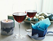Zwei Gläser Rotwein, umgeben von Weihnachtsdeko
