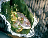 Whole Fish in a Banana Leaf with Scallions and Lemon on a Charcoal Barbecue