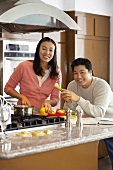 Young couple chopping vegetables in kitchen