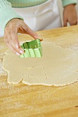 Holding a Cookie Cutter Over Rolled Out Dough