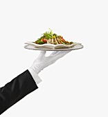 A Gloved Hand Holding a Silver Tray with Chicken Salad