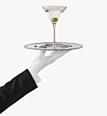 A Gloved Hand Holding a Silver Tray with a Martini
