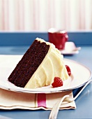 A Slice of Chocolate Cake with Vanilla Frosting and Raspberries