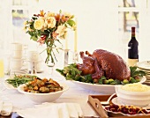 A Table Set with Roast Turkey, Artichokes, Mashed Potatoes and Cranberries