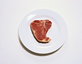 A Raw T-Bone Steak on a Plate