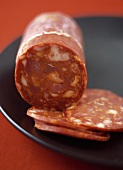 Chorizo with Slices on a Black Plate, Close Up