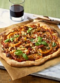Sausage and pepper pizza with basil