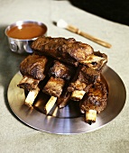 Barbecued short ribs on a silver plate with sauce