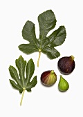 Whole and Peeled Figs with Fig Leaves on White Background