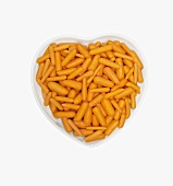 Overhead of Raw Baby Carrots in White Heart Shaped Bowl; White Background