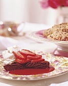 Chocolate cake with strawberry sauce and cream