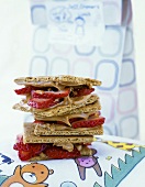 Peanut Butter and Strawberry Sandwiches on Graham Crackers Stacked on Plate